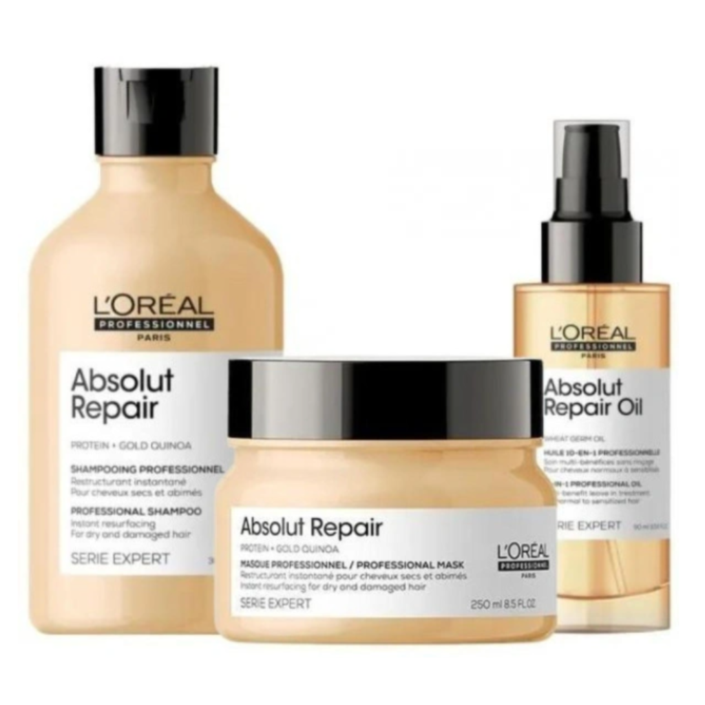 Pack de productos L'Oréal Professionnel Absolut Repair con proteína y quinoa dorada. Incluye champú, mascarilla y aceite reparador en envases dorados con detalles negros y blancos, diseñados para restaurar y nutrir el cabello dañado.